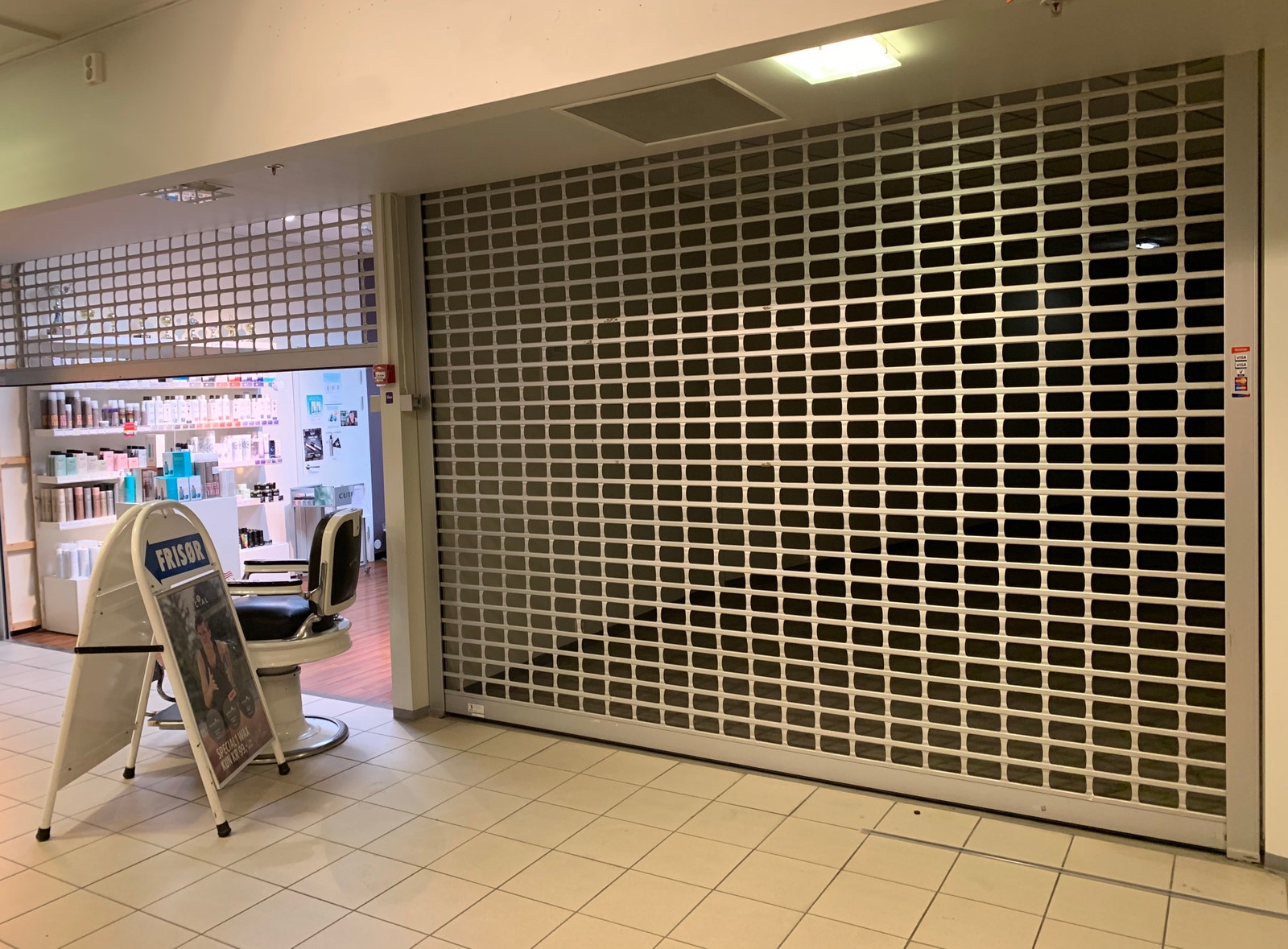 Inngangspartiet har rullegitter som deler arealet fra eiendommens fellesareal på etasjen. Galleribilde