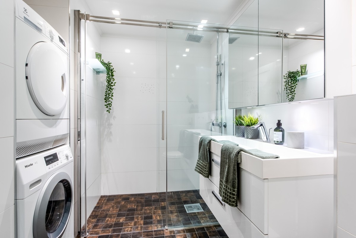 Badet har servantinnredning med underskuffer og speilskap over. Elegant dusjhjørne med skyvbar glassdør. Galleribilde