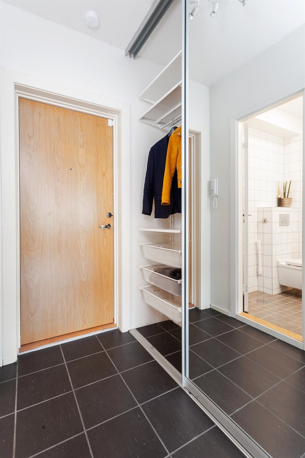 Flislagt entré med stor skyvedørsgarderobe. Galleribilde