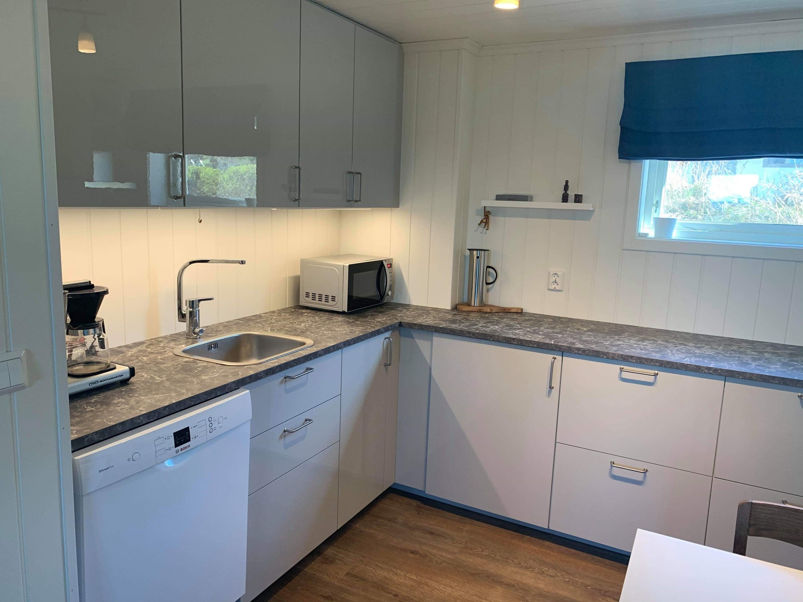 Kjøkken med oppvaskmaskin, komfyr og kjøleskap. Galleribilde