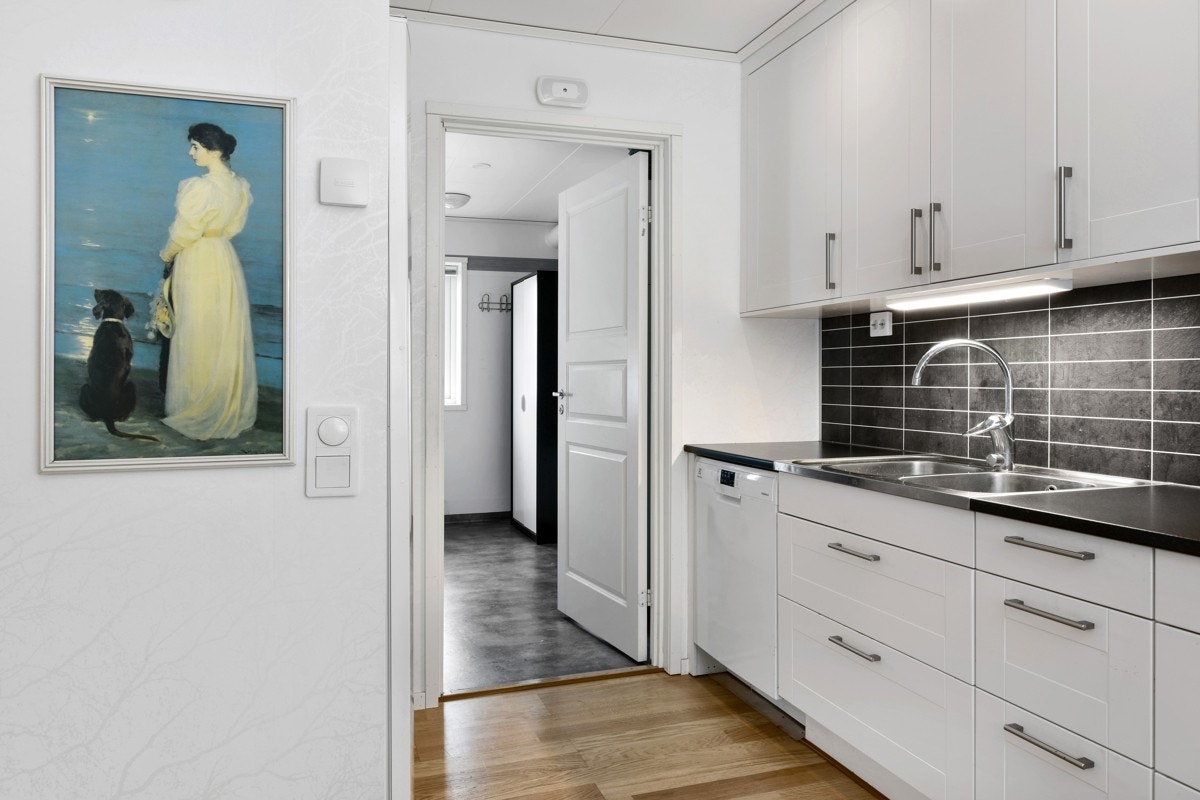Veggen mellom benker og overskap er platekledd, og det er montert downlights i himling. Galleribilde