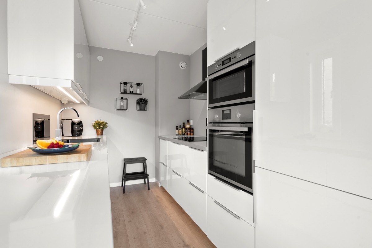 Kjøkken og stue/spisestue ligger i delvis åpen løsning for en sosial og livlig leilighet Galleribilde