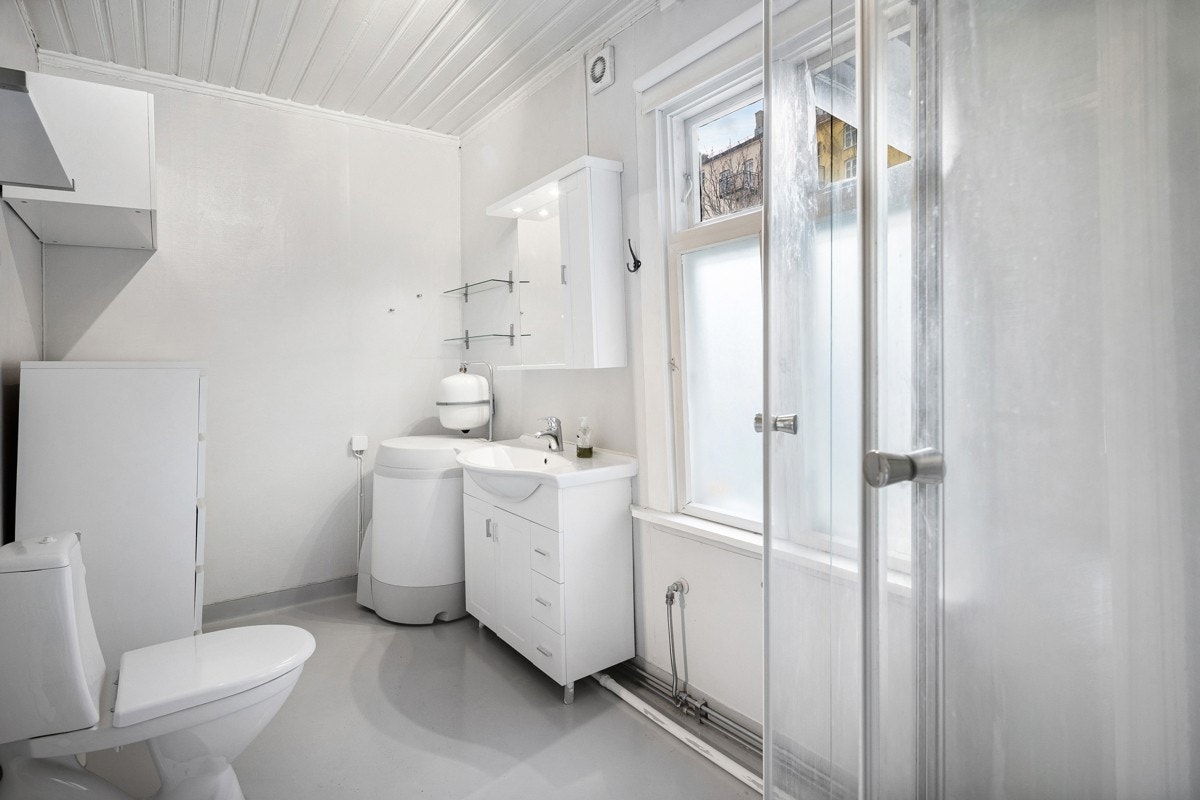 Lyst bad med dusjkabinett, servant og toalett. Galleribilde