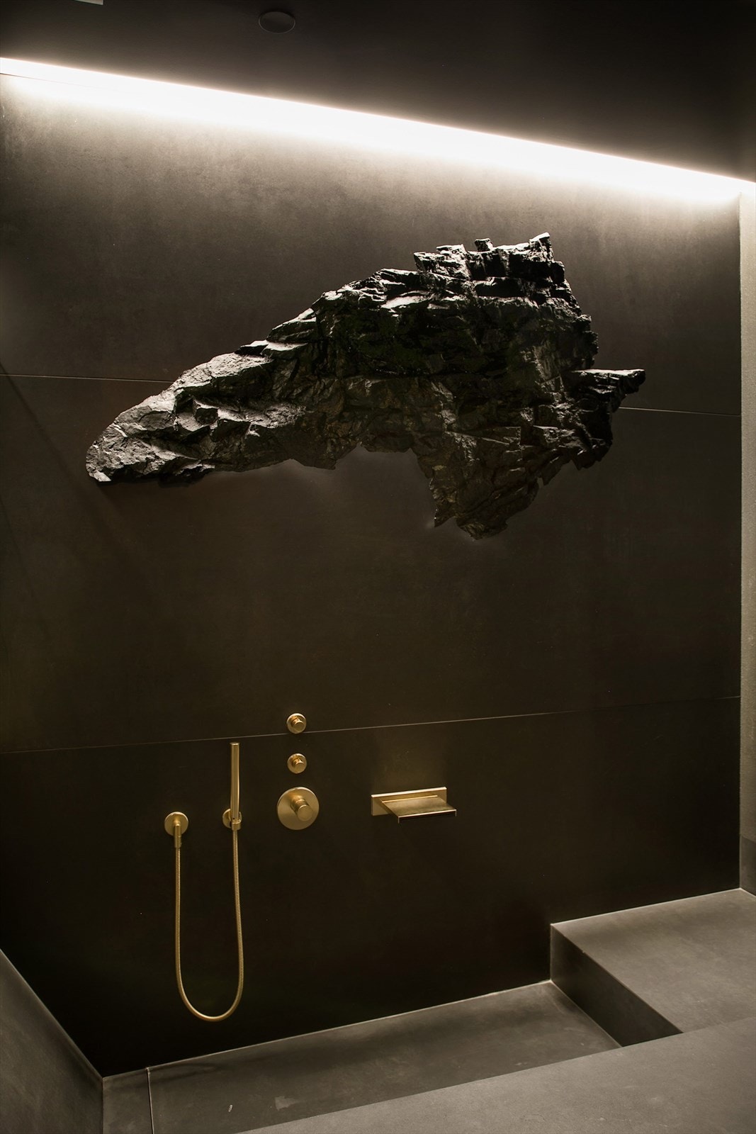 Over badekaret henger skulpturen "Boulder" av Aleksander Stav. En livaktig kopi av en kampestein fra Rørosvidda. Galleribilde