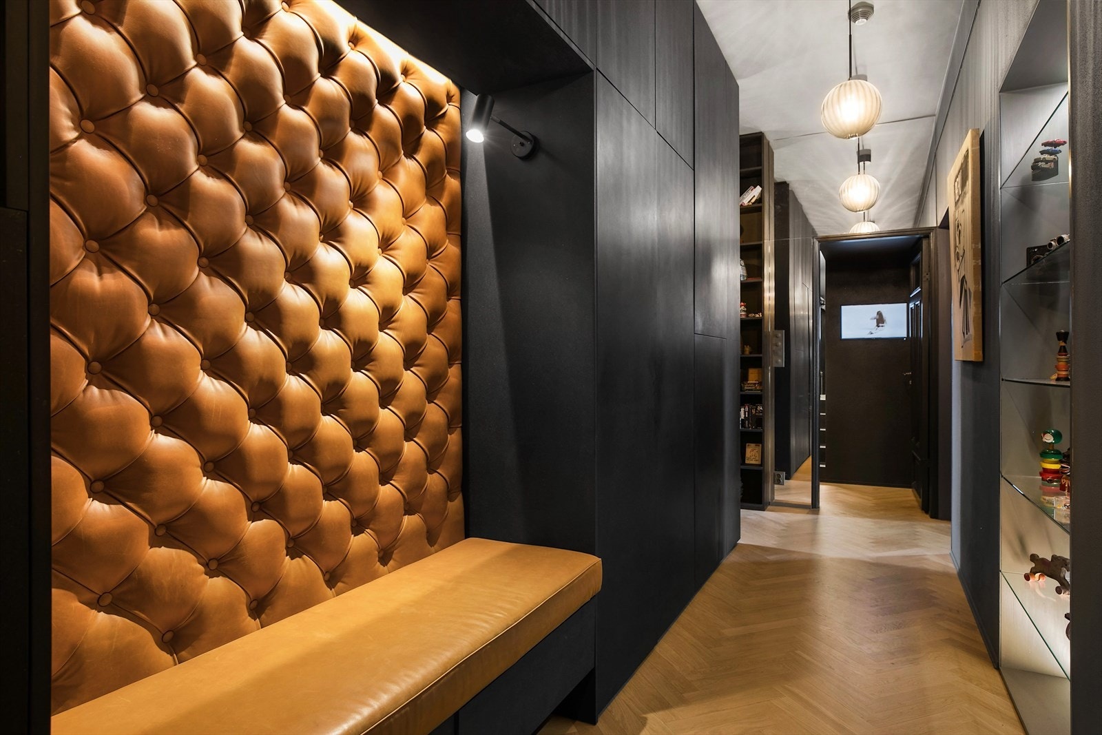 Gang med integrerte garderobeskap i Valchromat og designet skinnsofa. Leilighetens kommunikasjonsåre brukes også som galleri. Garderobeskap skjuler også et spesialdesignet, stort tørkeskap. Galleribilde