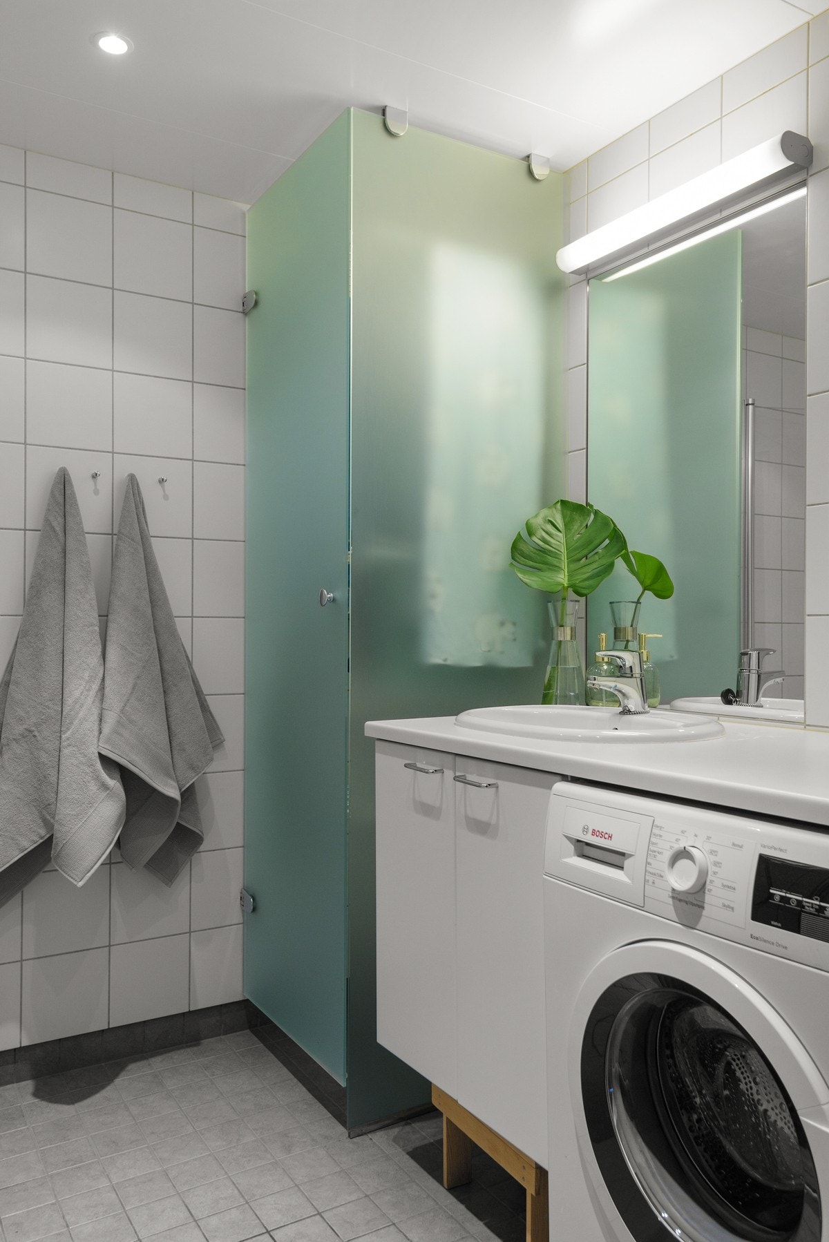 - Dusjnisje med dusjvegg, vegghengt toalett, servant med skap, stort tørkeskap i frostet glass og opplegg for vaskemaskin under praktisk benk - Galleribilde