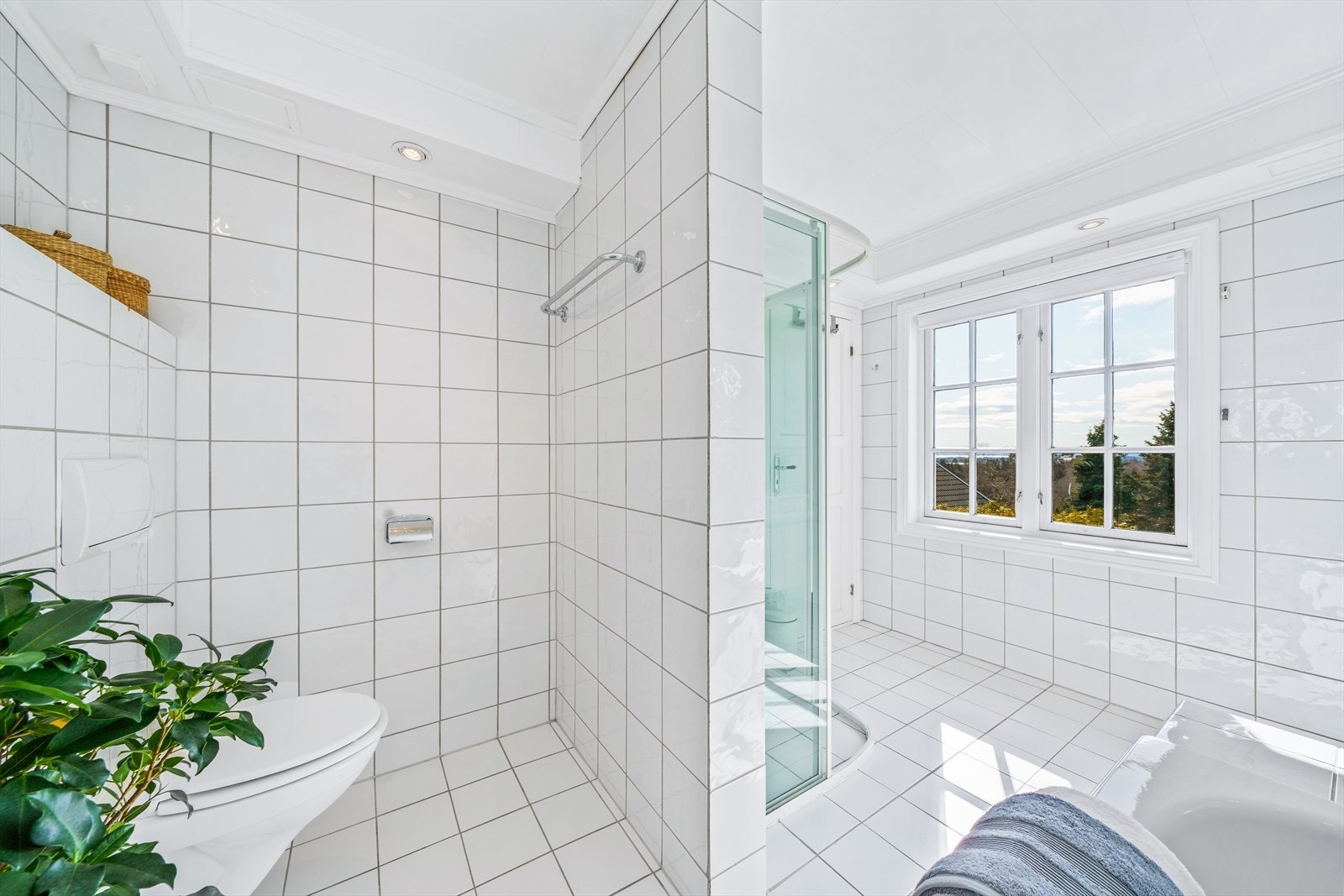 Badet har innmurt/flissatt badekar, dusjhjørne og varme i gulvet Galleribilde