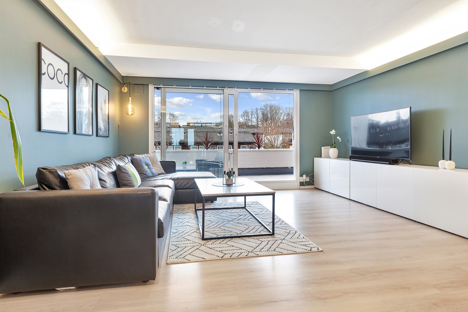 Lys og romslig stue med gjennomgående flott laminat på gulv Galleribilde