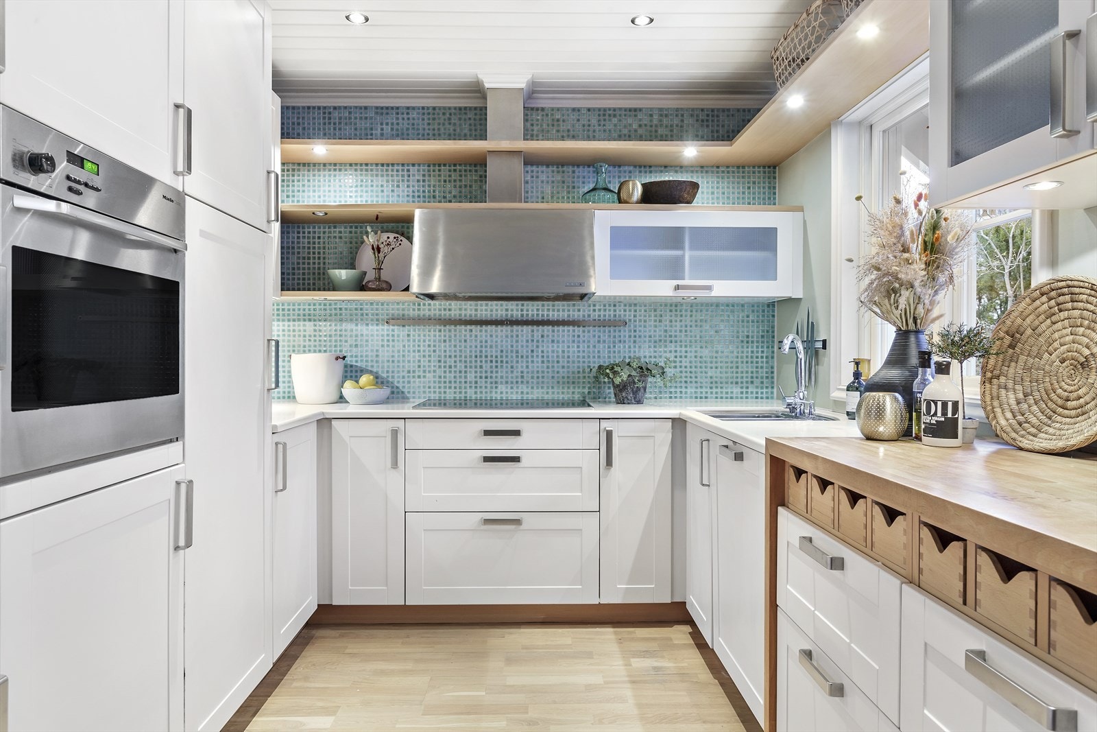 Delikat kjøkken fra med hvite glatte fronter og godt med skap- og benkeplass Galleribilde