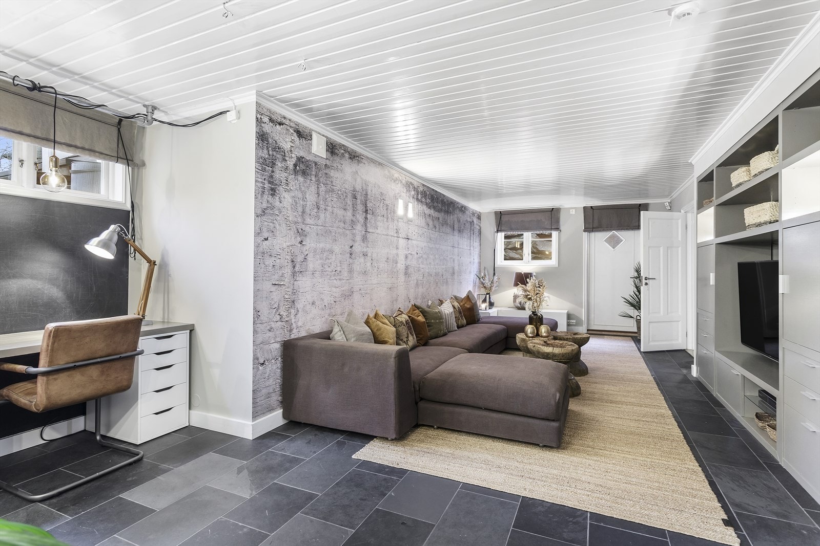 Stor og stilren kjellerstue med peisovn og plassbygd innredning på ca. 2,80 m med plass til TV og oppbevaring Galleribilde