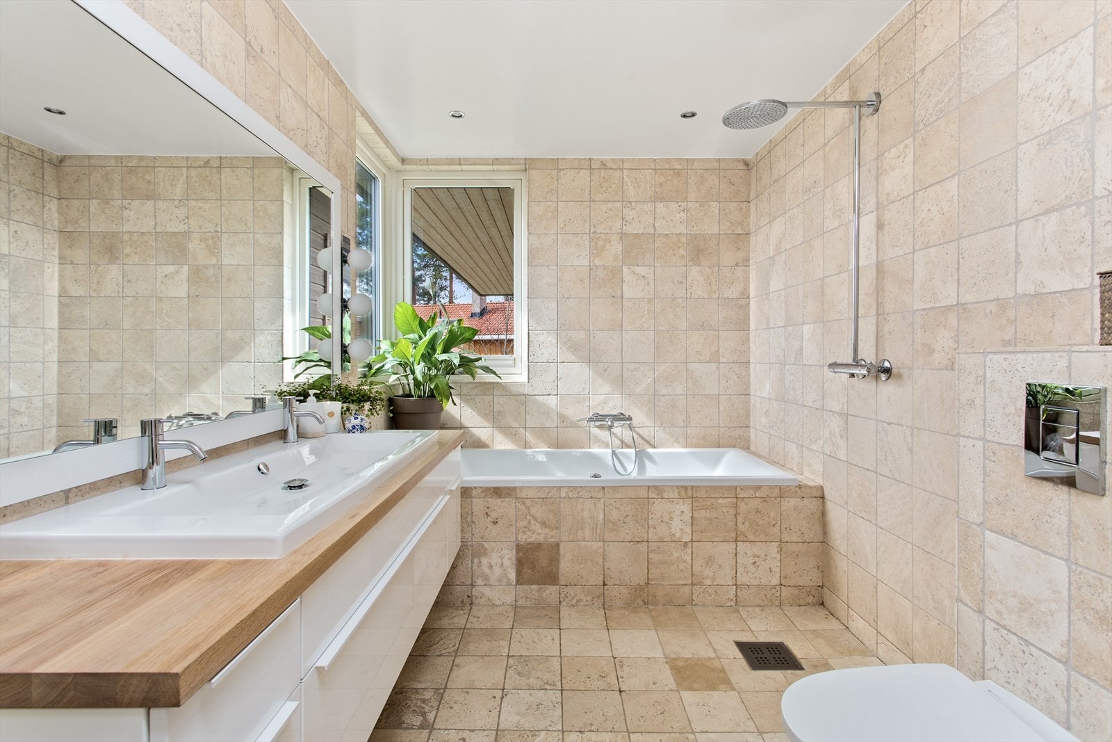 Badet er flislagt, har gulvvarme, et stort servantskap og rommer både badekar og dusj. Detaljrikt og velholdt! Galleribilde