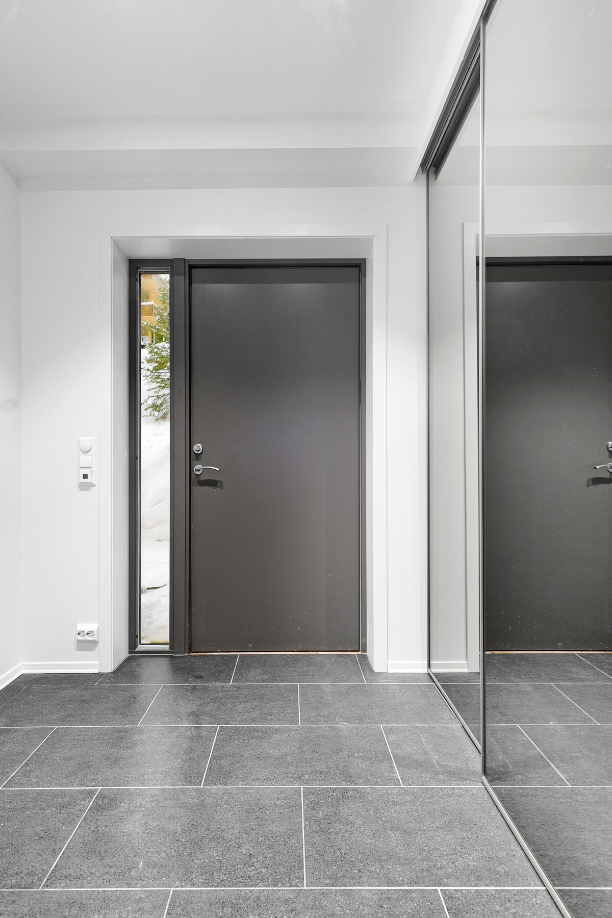Flislagt inngangsparti med gulvvarme og skyvedørsgarderobe