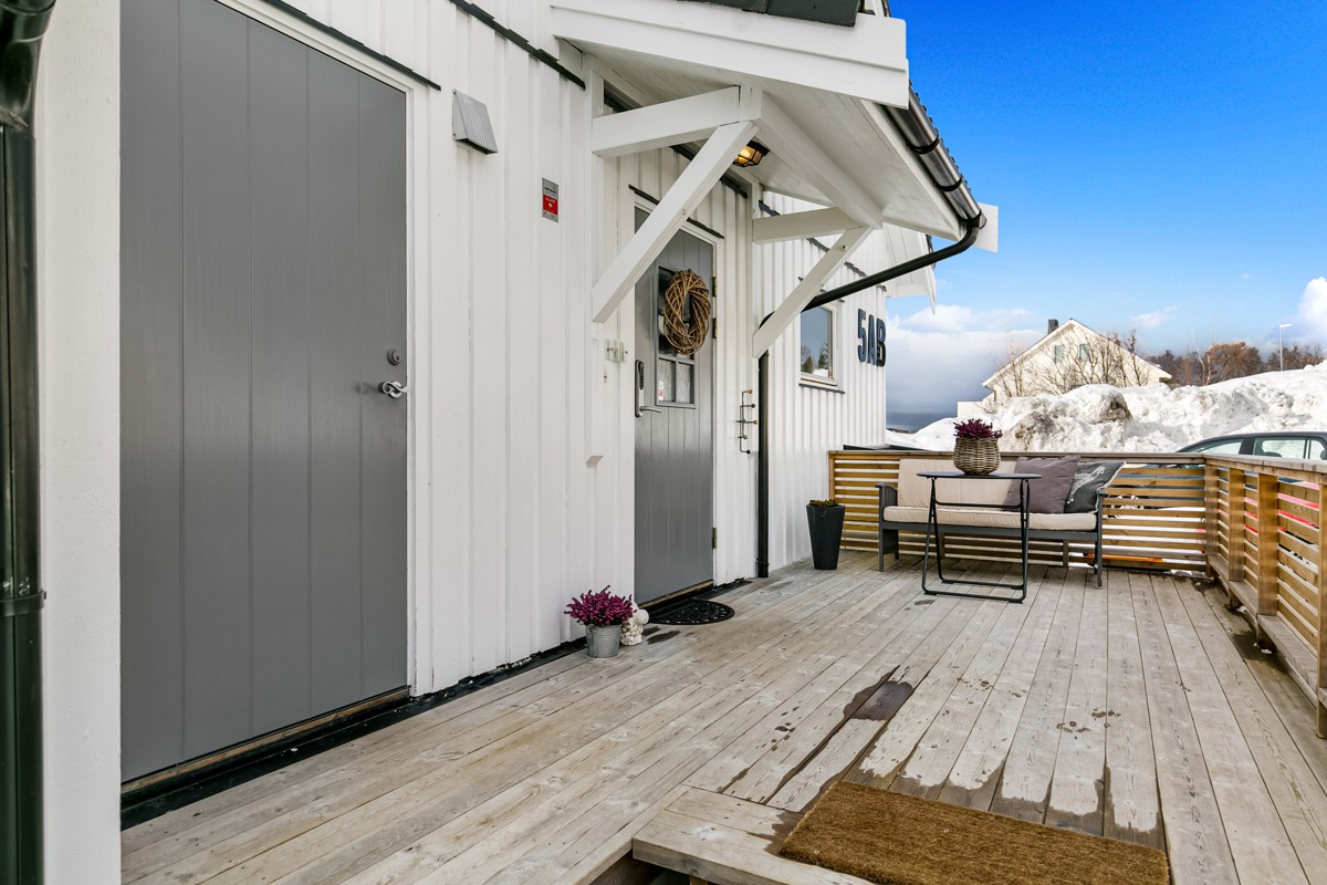 Terrasseplatt ved overbygd inngang og sportsbod med inngang til venstre i bilde