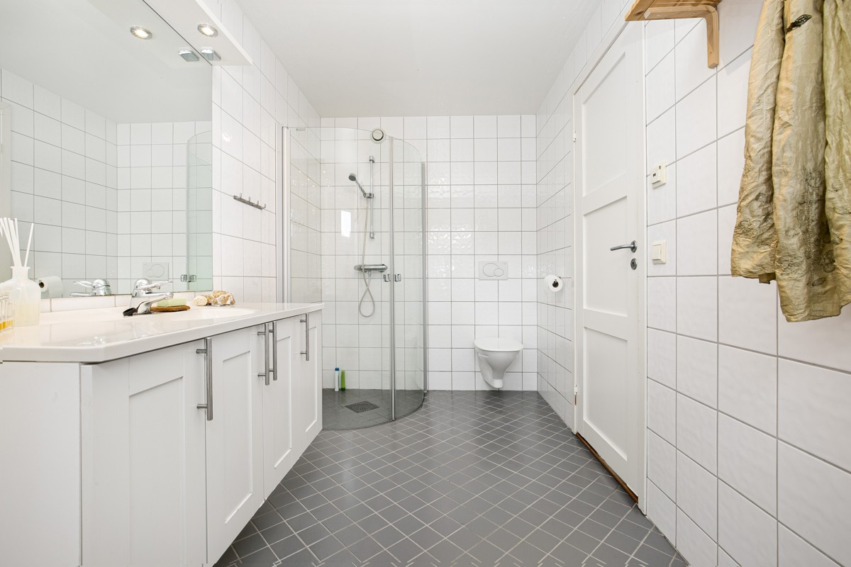 Badet i 2. etasje er fliselagt med dusj, servant og wc