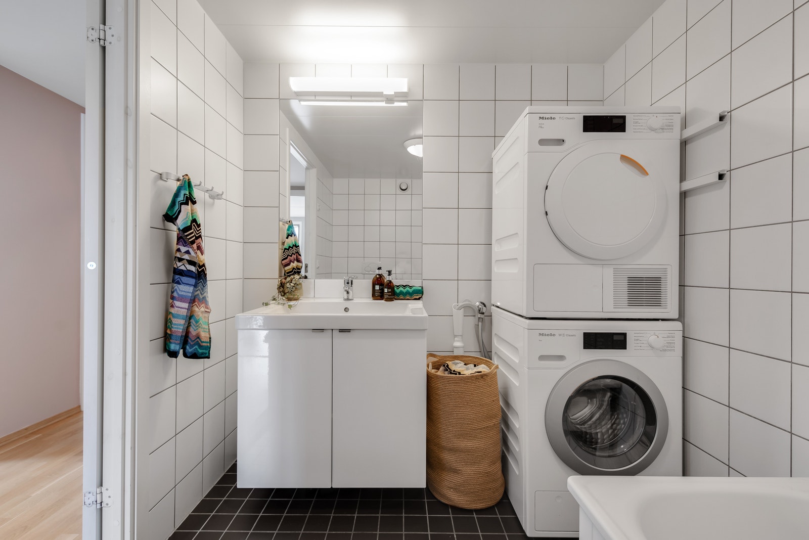 Hovedbad med opplegg for vaskemaskin og tørketrommel. Inneholder også badekar og wc. Galleribilde