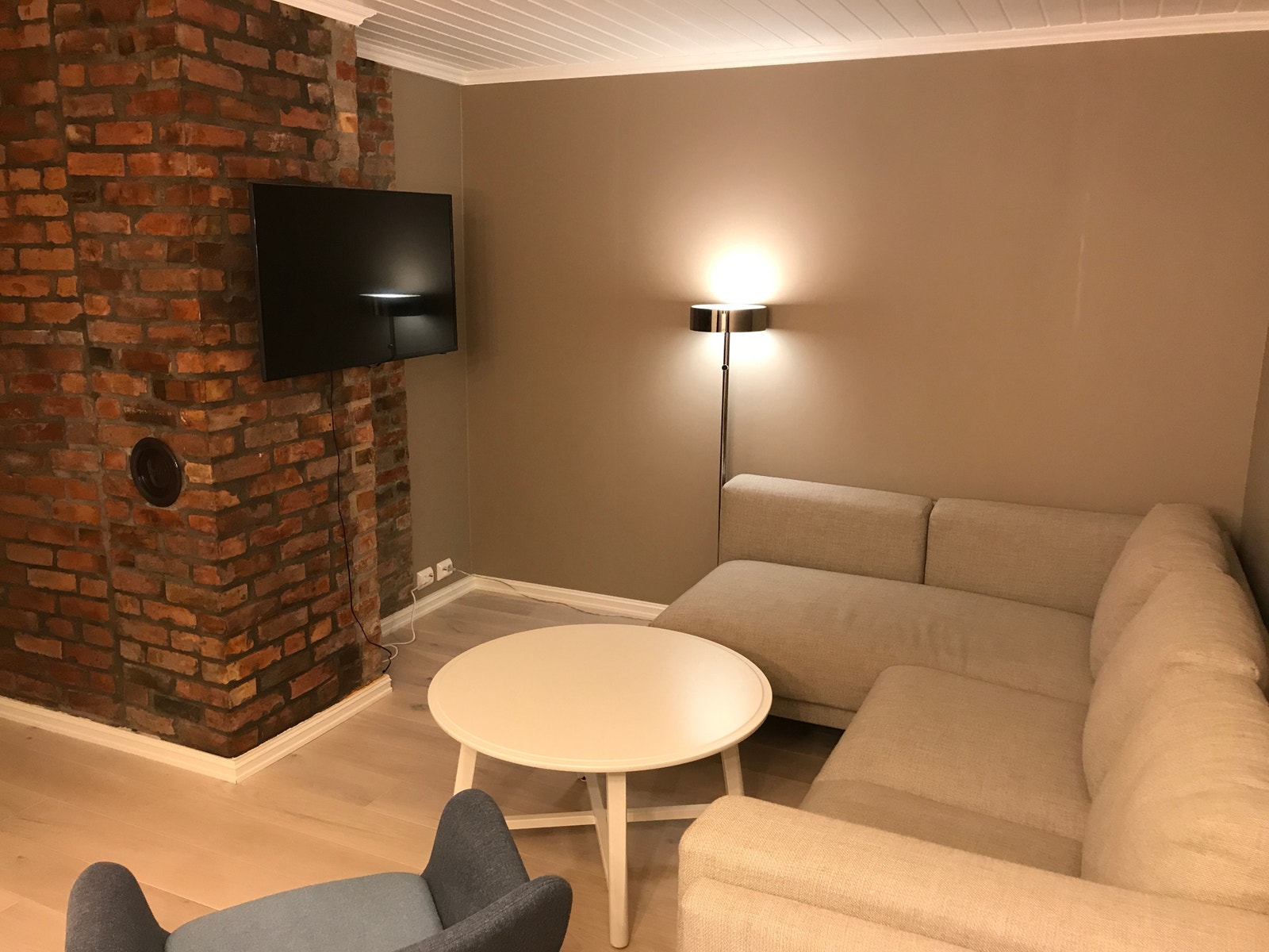 Stue med stor sofa, sofastol og tv Galleribilde