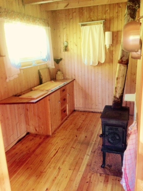 Kjøkken med benk skap og vedovn Galleribilde