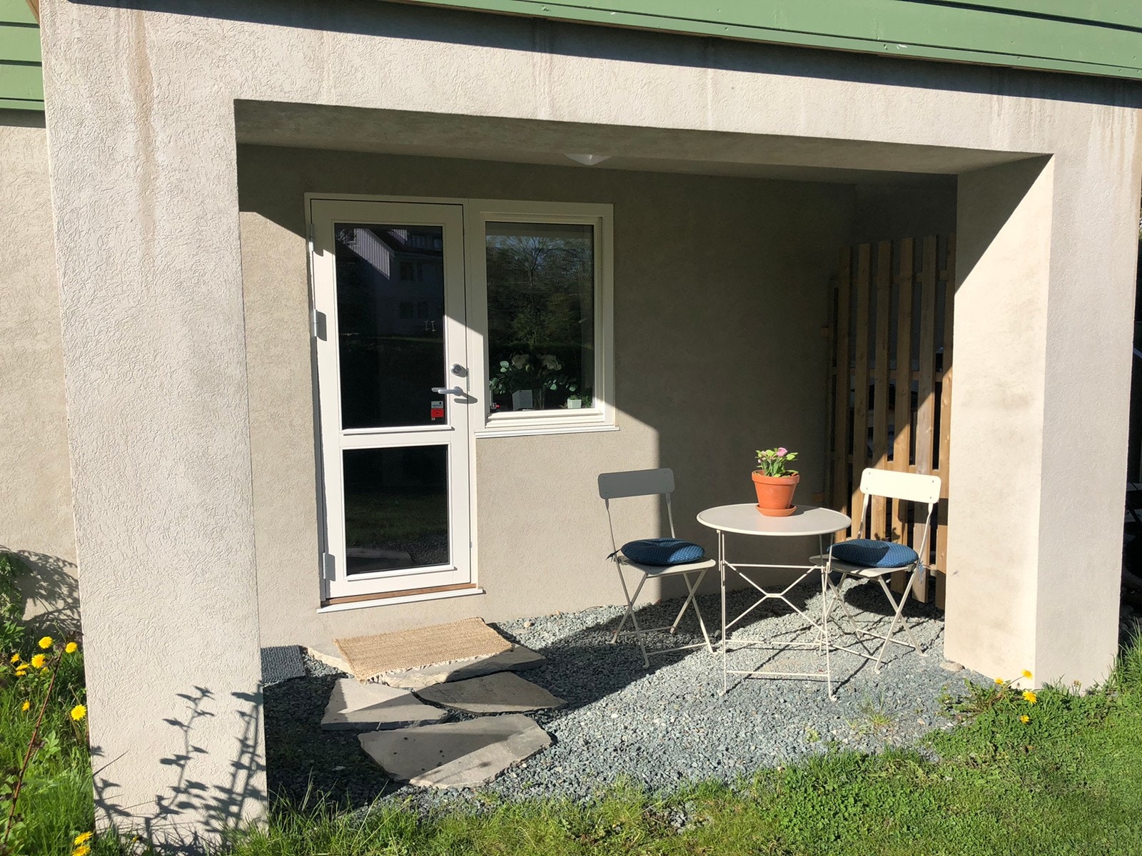 Skjermet uteplass med cafébord og stoler.
Treplatting er etablert etter bildet ble tatt, så det er vesentlig penere opparbeidet! Galleribilde