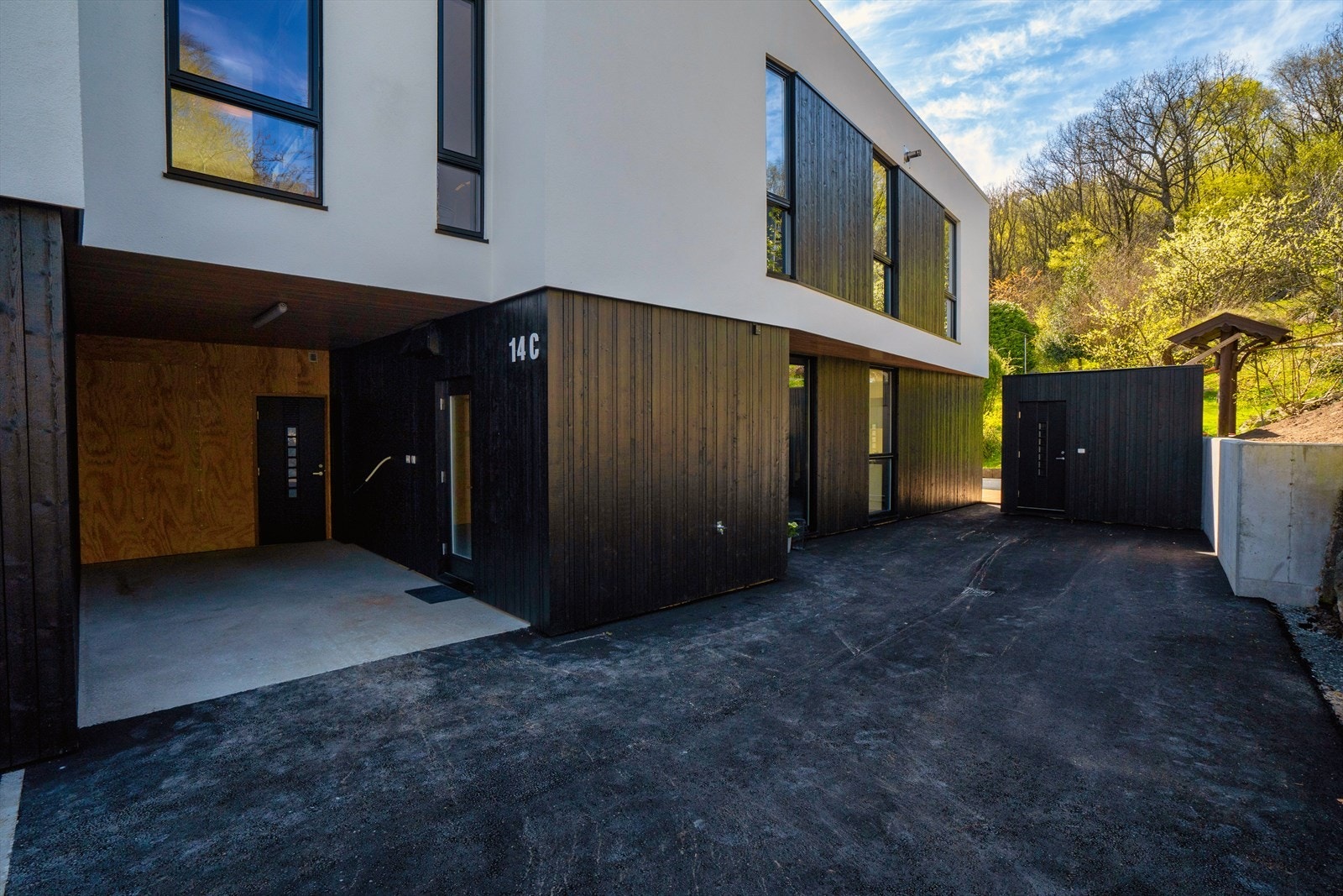 Innkjørsel med carport og bod i bakkant. I tillegg frittstående bod ved inngangsparti Galleribilde