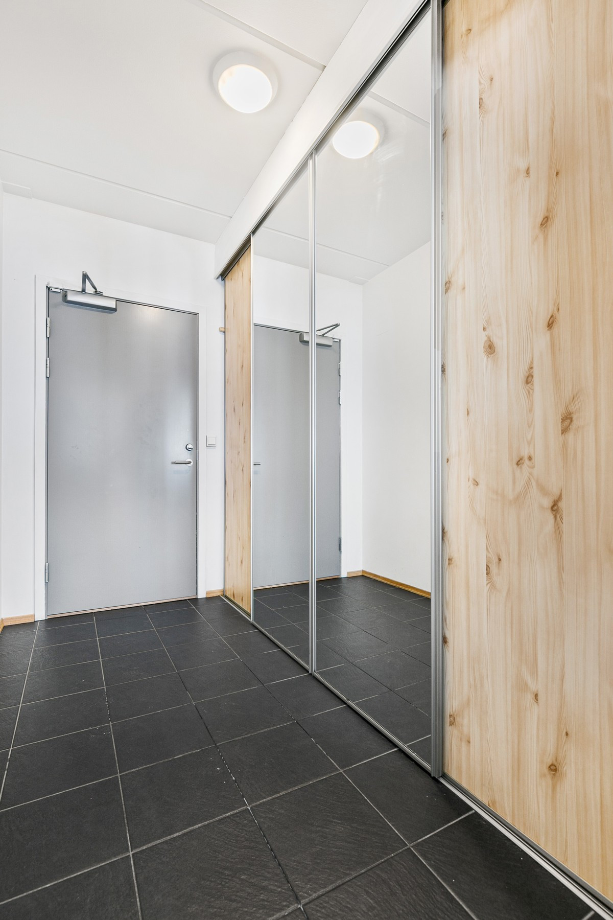 Entré med speilgarderobe og fliselagt gulv med varme