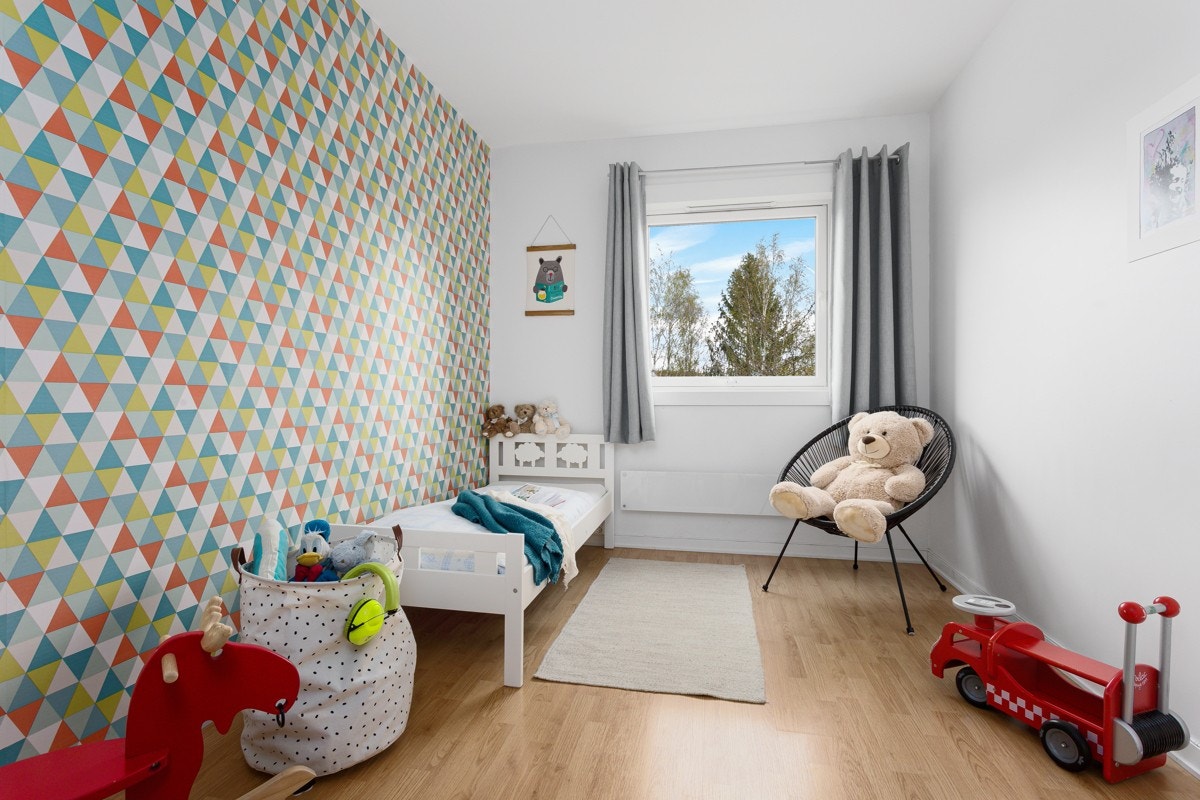 Det ene soverommet har en stilig tapet med geometrisk mønster og et lekent fargevalg. Galleribilde