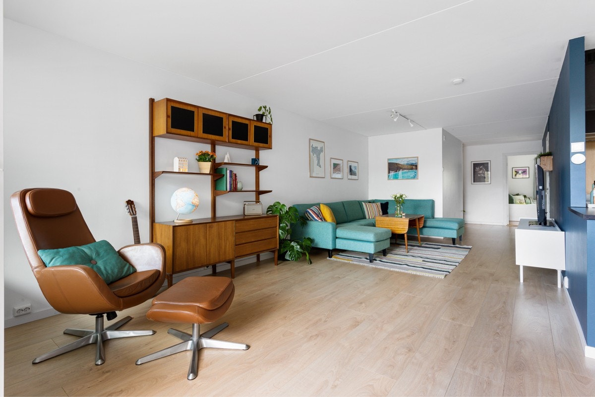 Stuen har lysmalte vegger og en mørkere fondvegg som gir rommet dybde og karakter. Galleribilde