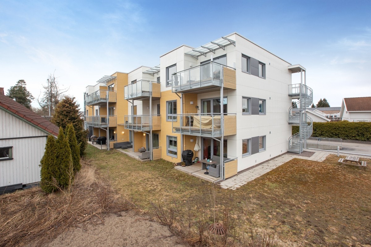 Fasade bakside med fellesområde og nedkjøring til parkeringskjeller. Galleribilde