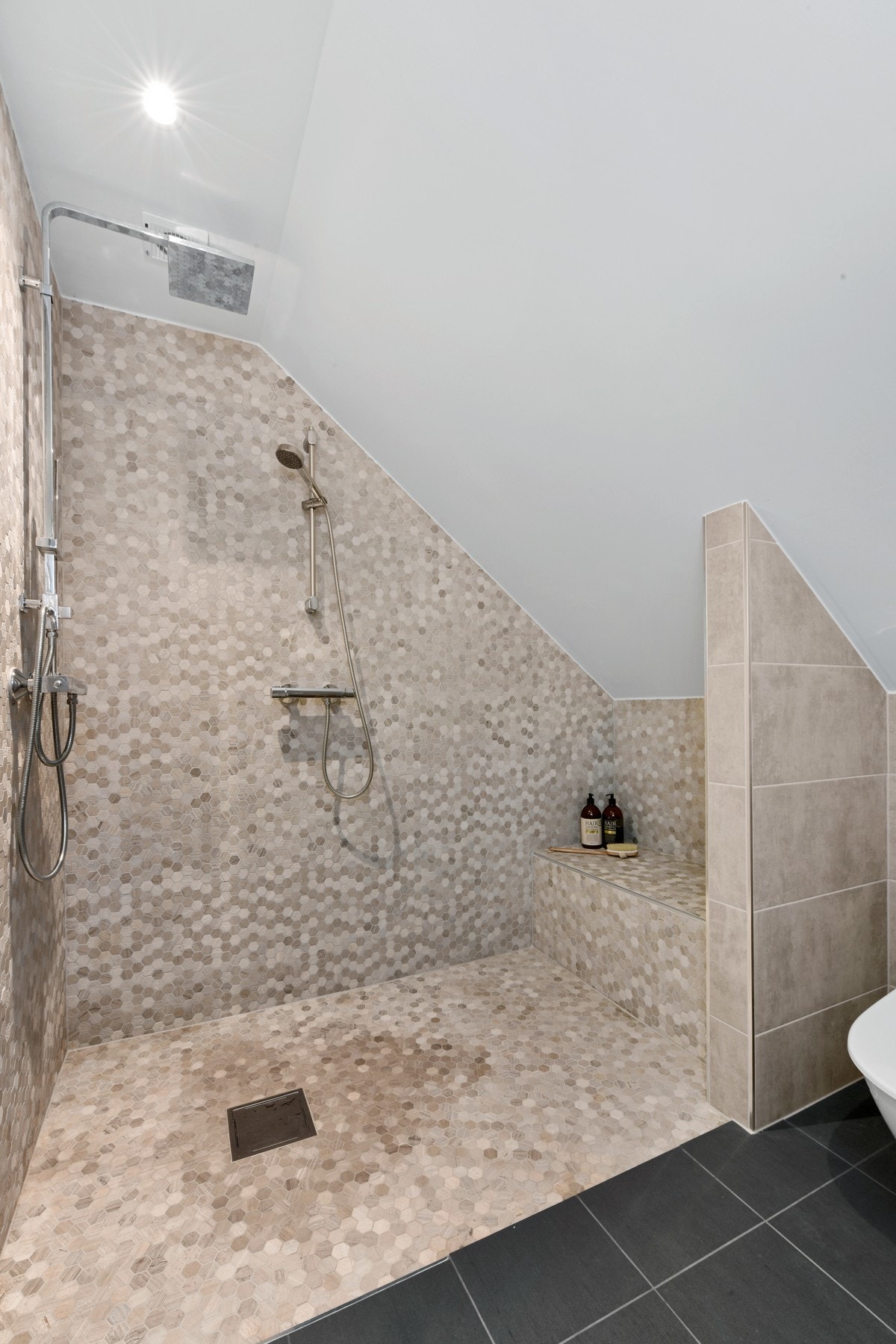 Det flotte badet i andre etasje er fra 2019. Det har sorte gulvfliser og veggfliser i en sandfarget tone. Badet har gulvvarme og downlights. Ellers er det utstyrt med frittstående toalett og en lekker dusjsone. Galleribilde