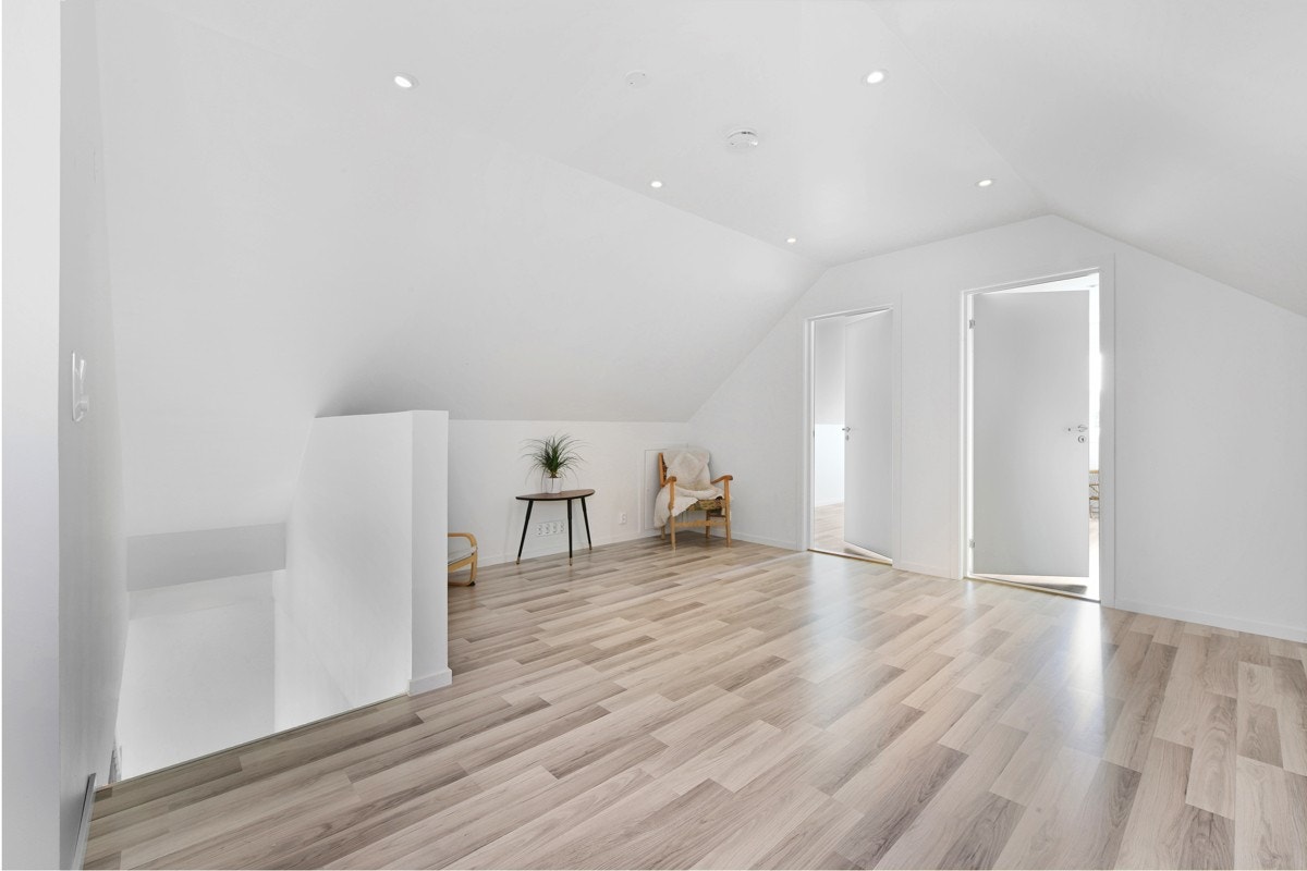 Loftstuen har plass til både sofaløsning med tilhørende møblement og en kontorkrok, noe som gir ekstra spillerom og privatliv for barnefamilier. Rommet har laminatgulv, hvitmalte vegg- og himlingsflater, skråtak og downlights. Galleribilde