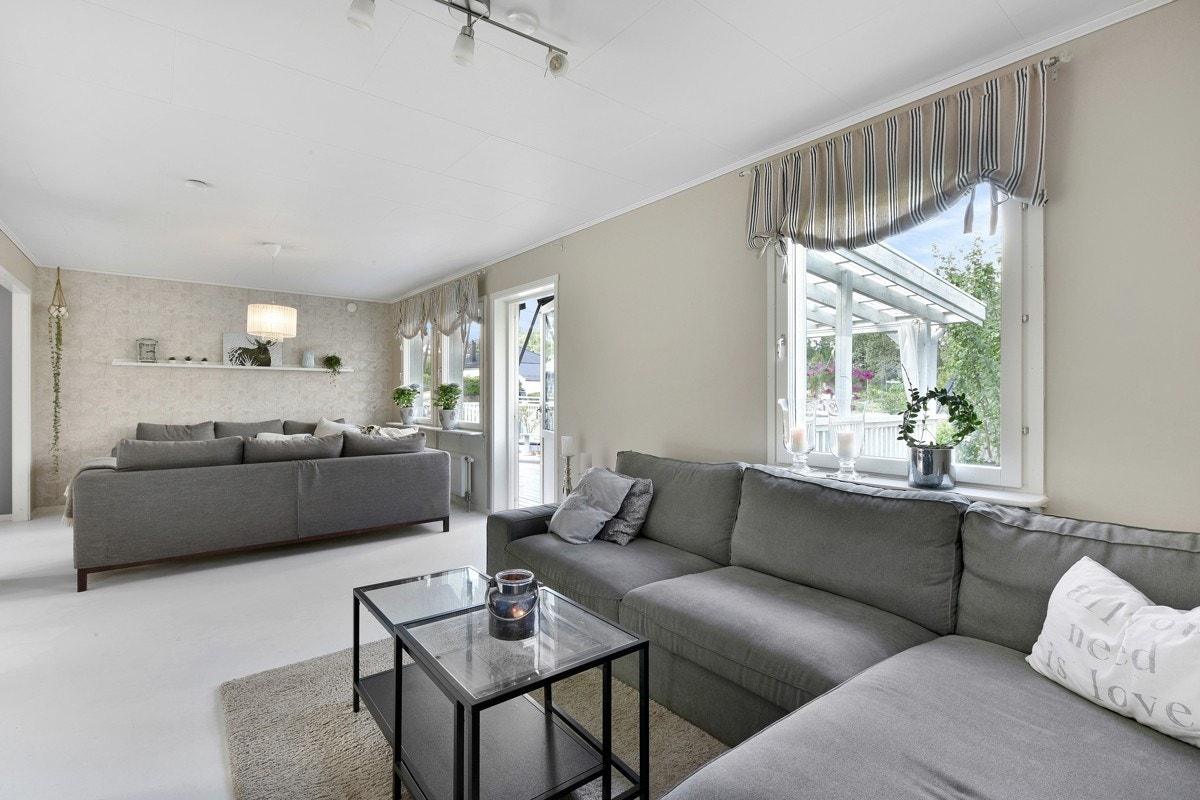 Rommet har gråmalt parkettgulv, og gråmalte vegger i delen ved kjøkkenet. De øvrige flatene er holdt i lyse toner. Galleribilde