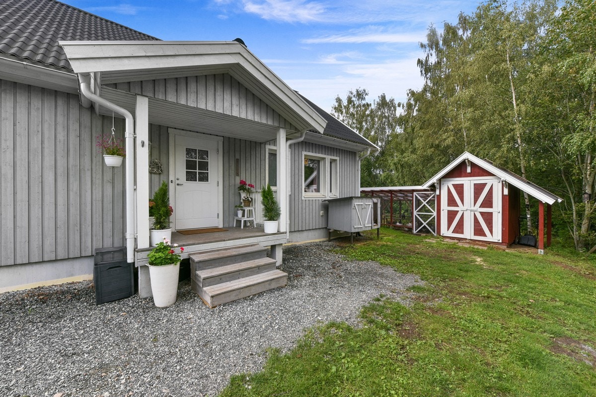 Fra den gruslagte gårdsplassen er det adkomst til boligen via et overbygd inngangsparti med trapp. Galleribilde