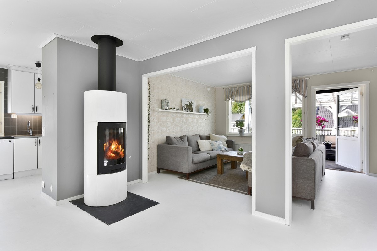 Den ene delen ligger tilknyttet kjøkkenet og har masser av plass til et langbord. Her er det satt inn en klebersteinsovn i hvitt og sort - et flott blikkfang som gir ekstra varme og hygge på kalde kvelder. Galleribilde