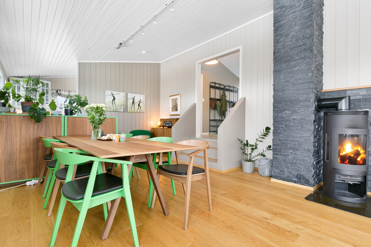 Det er god plass til stort spisebord i overgang fra stue til kjøkken - her varmer også peisen godt