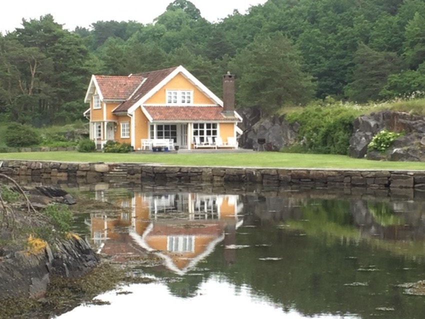 Bilde hvor hytten speiler seg i sjøen Galleribilde