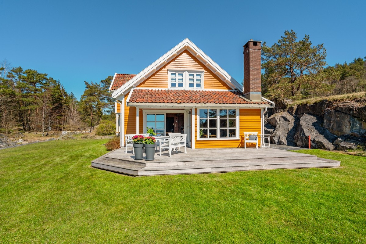 Hytten ligger flott til med stor plen utenfor Galleribilde