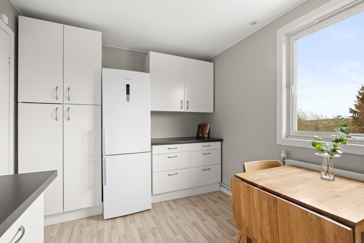 Innholdsrik kjøkkeninnredning med mye skap- og benkeplass. Galleribilde