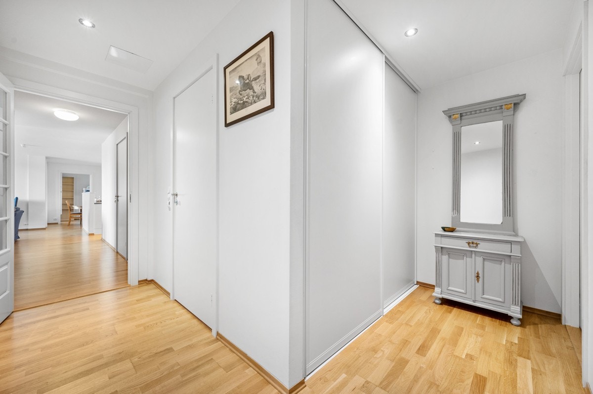 Romslig entre med skyvedørsgarderobe, dør inn til toalettrom Galleribilde