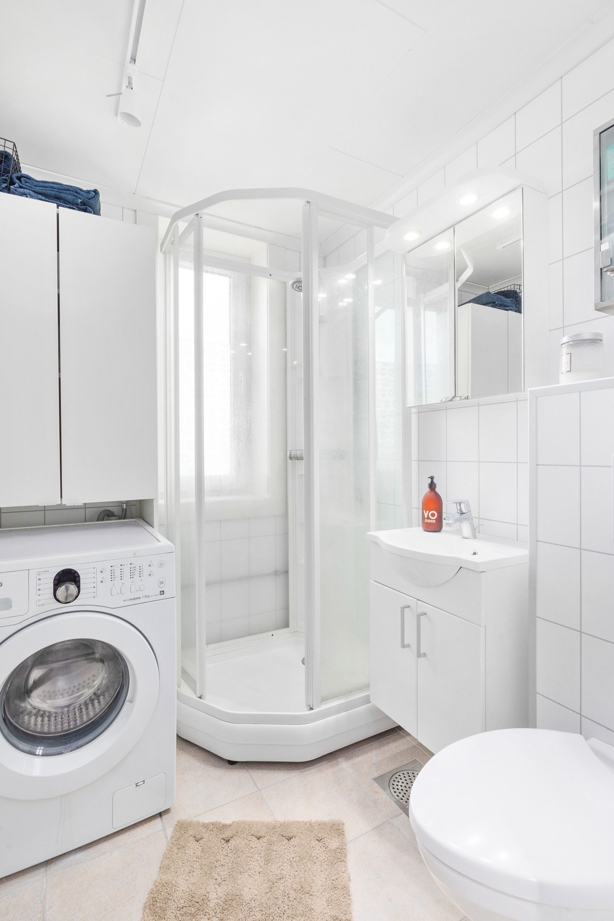 Badet har dusjkabinett, toalett, servant med underskap samt opplegg til vaskemaskin Galleribilde