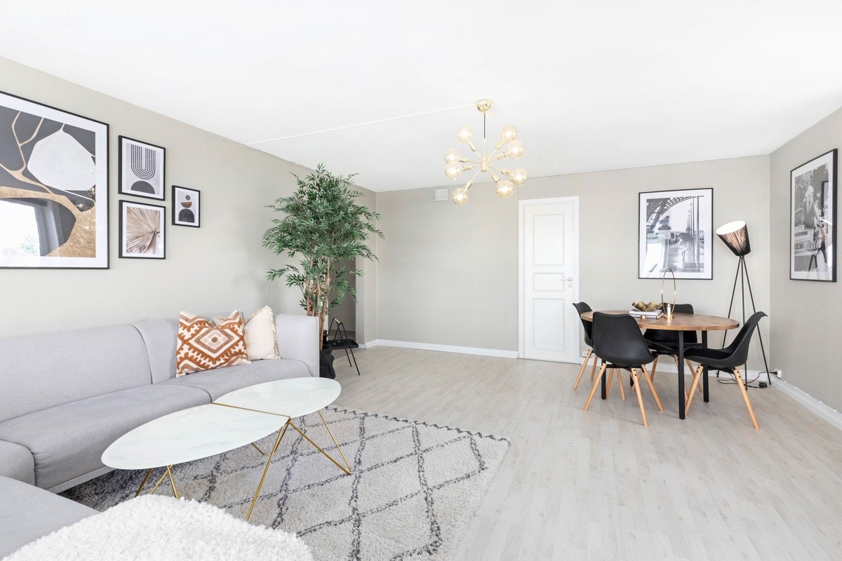 Leiligheten har en lys og åpen stue med plass til både sofagruppe og spisebord Galleribilde