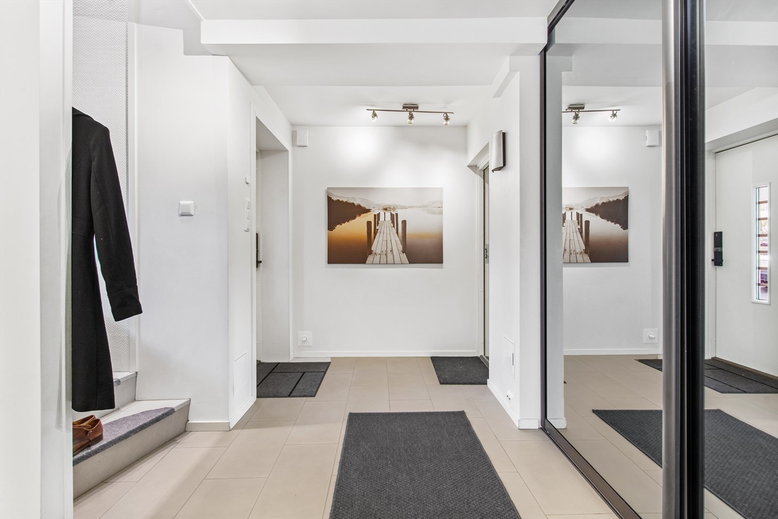 Romslig entré i boligens 1. etasje. Entréen har stor skyvedørsgarderobe med speil. Galleribilde