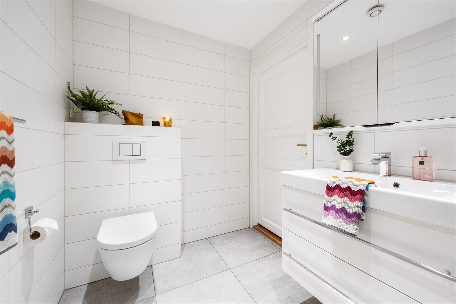 Innredningen består av servant med underskap og overskap med speil, dusjhjørne med glassvegg og vegghengt toalett. Galleribilde