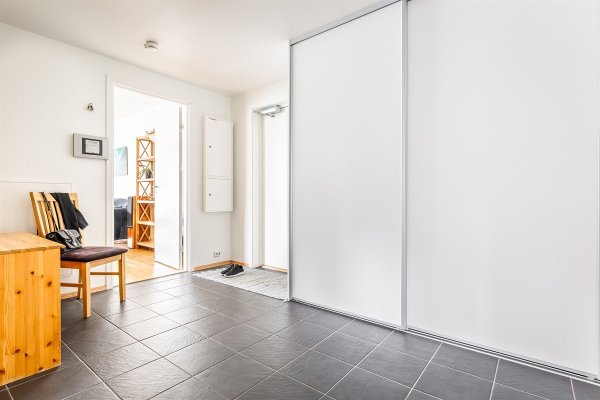 Entrê med skyvedørsgarderobe. Leiligheten har vannbåren varme fra felles varmesentral i alle gulv.