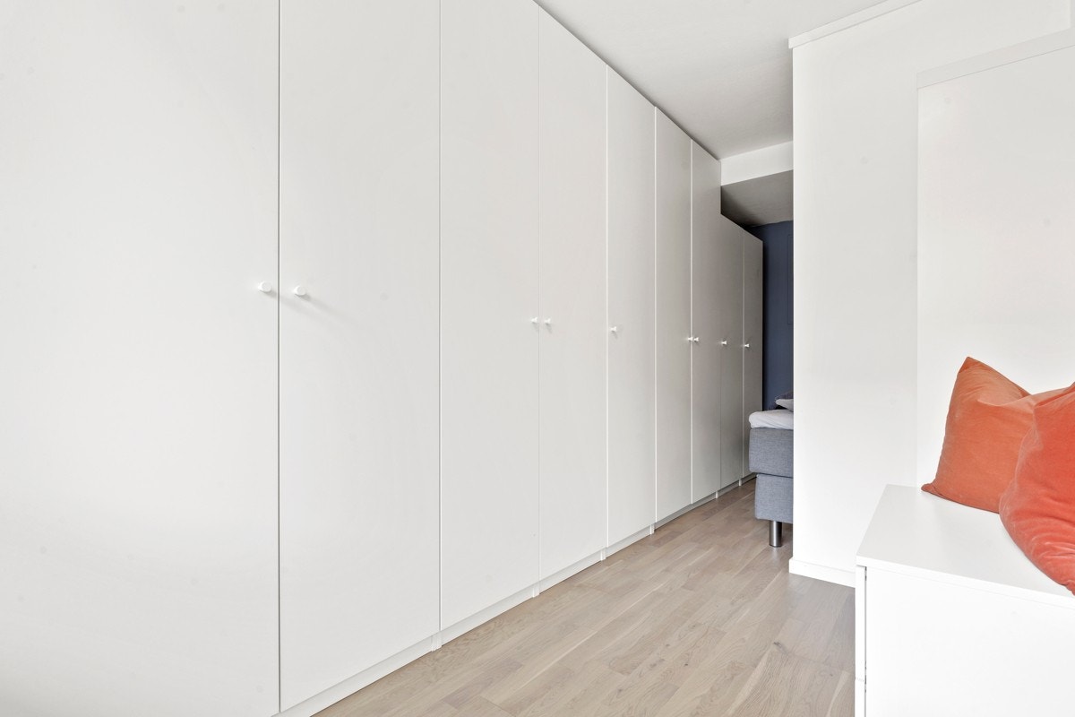 Sjenerøst med garderobeskap langs vegg som går fra entré og fortsetter inn i alkove. Galleribilde