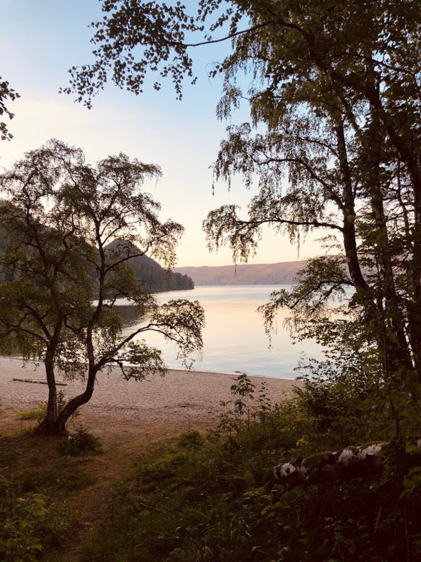 Sandstranden ligger idyllisk til ved Holsfjorden. Galleribilde