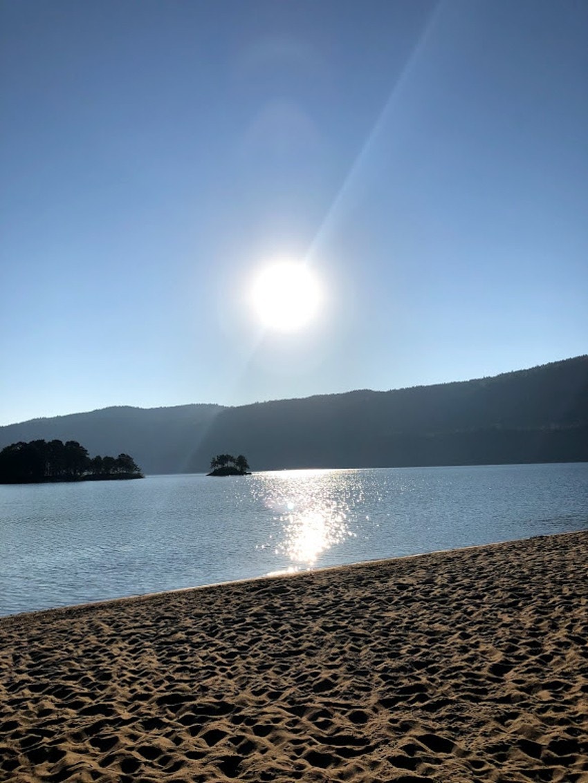 Langrunnt vann og finkornet sand på Sandstranden. Galleribilde