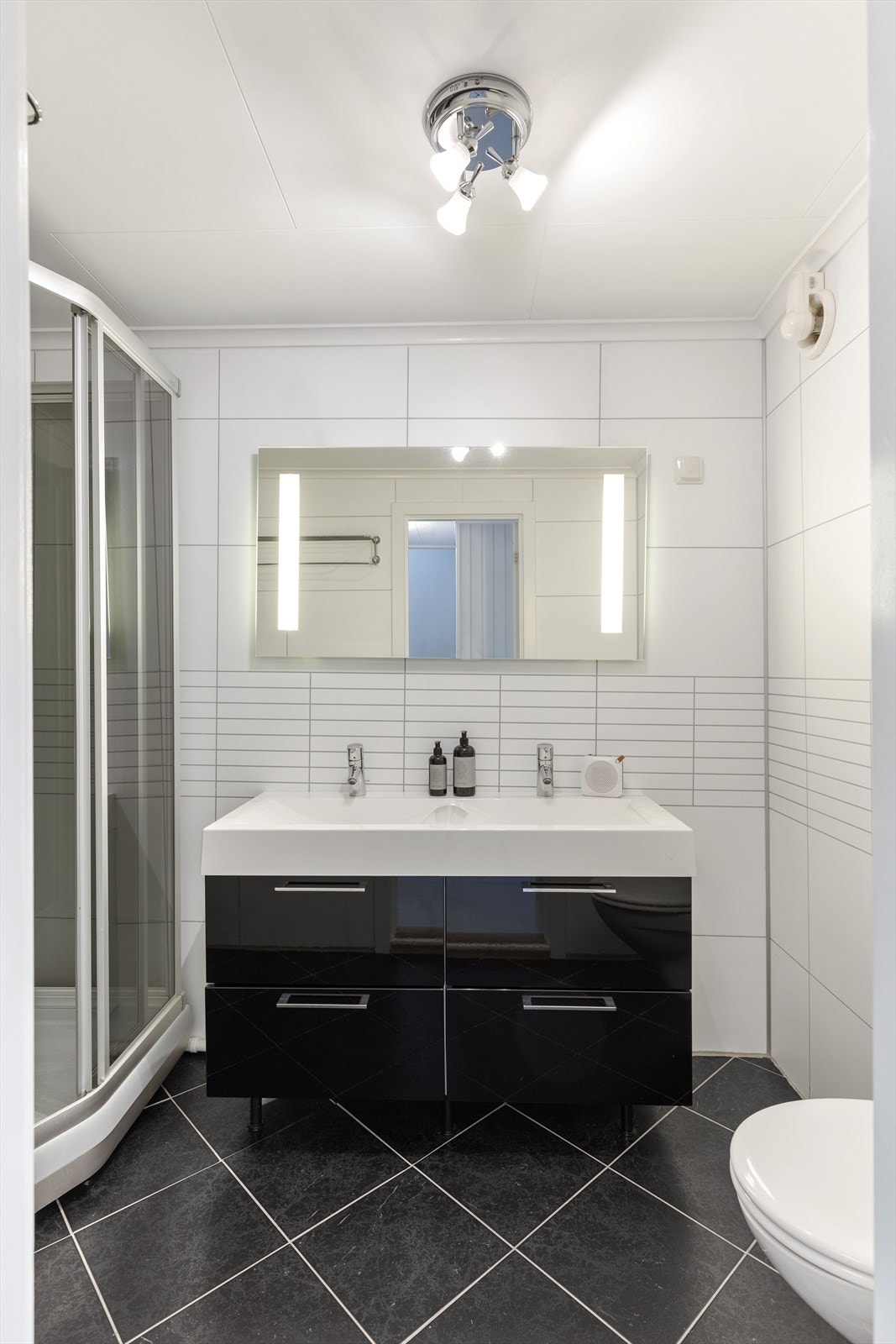 Flott bad oppusset i 2008. Sort innredning med dobbel servant. Dusjkabinett. Vegghengt toalett. Varmekabler. Galleribilde