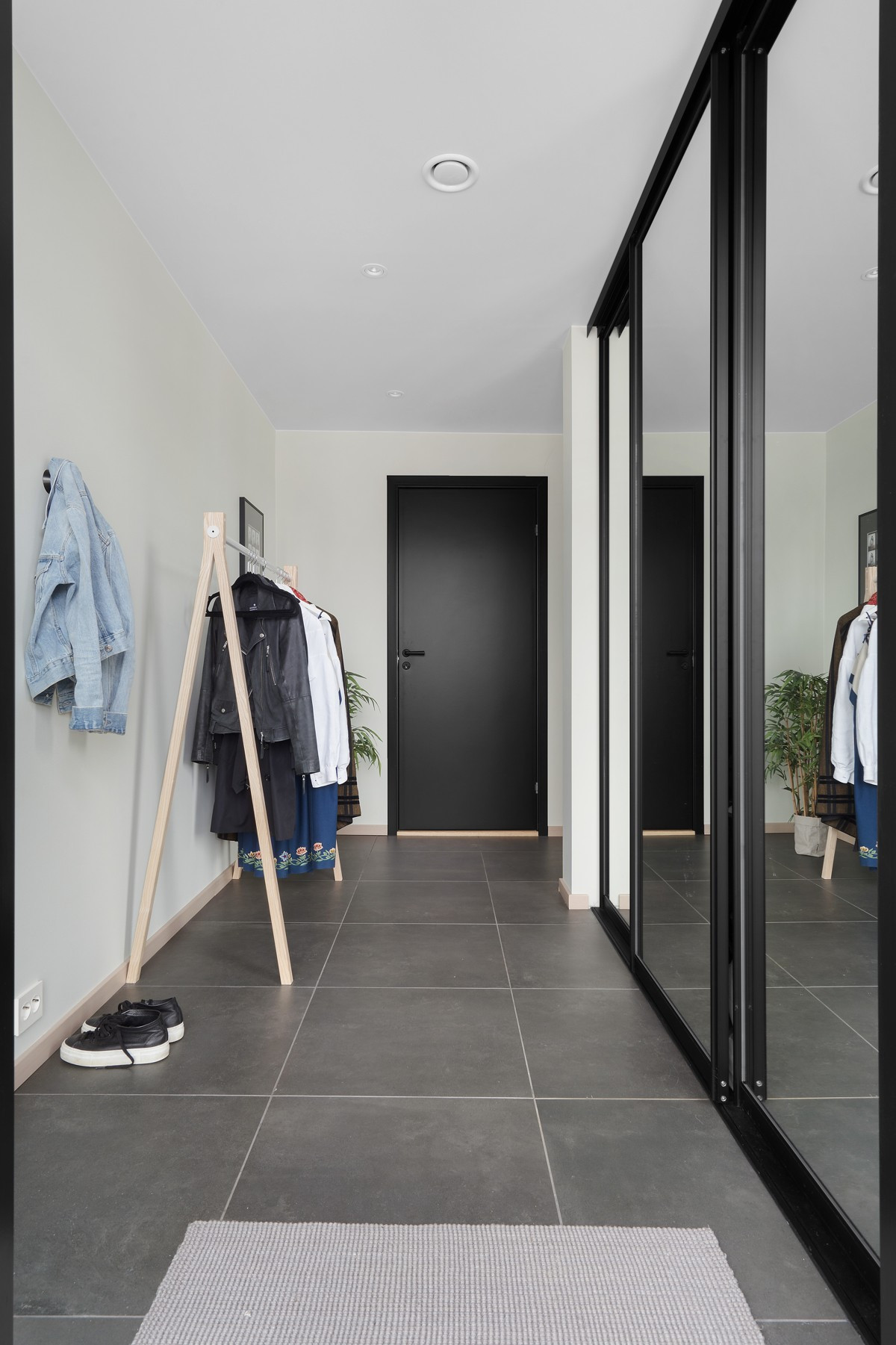 Gang med skyvedørsgarderobe og fliser på gulv