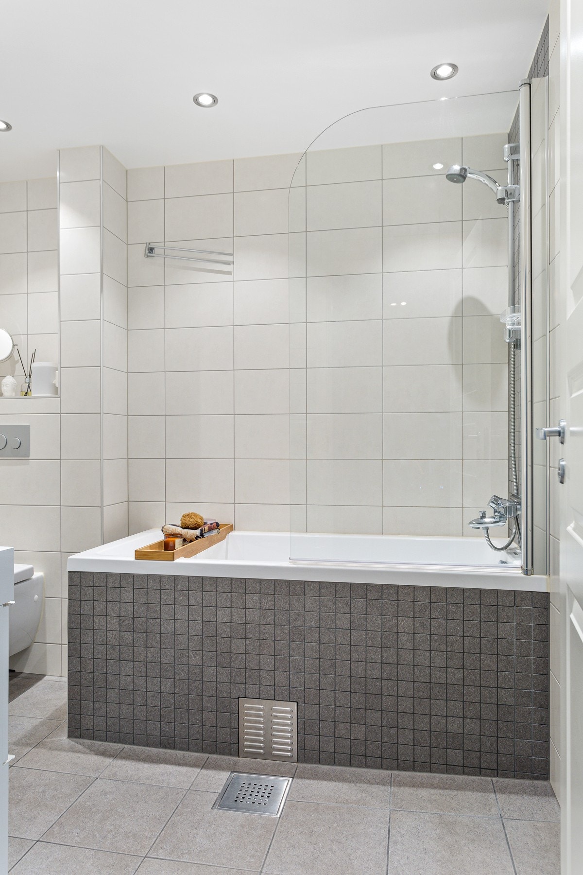 Gulvet har delikate fliser i 30 x 30 cm, veggen har fliser i 20 x 33 cm og badekaret har stilig mosaikkflis. Galleribilde