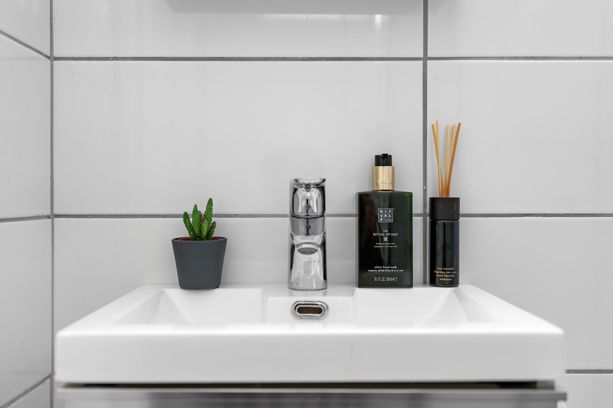 Badet inneholder wc, dusjhjørne med foldedører og servant med over- og underskap Galleribilde