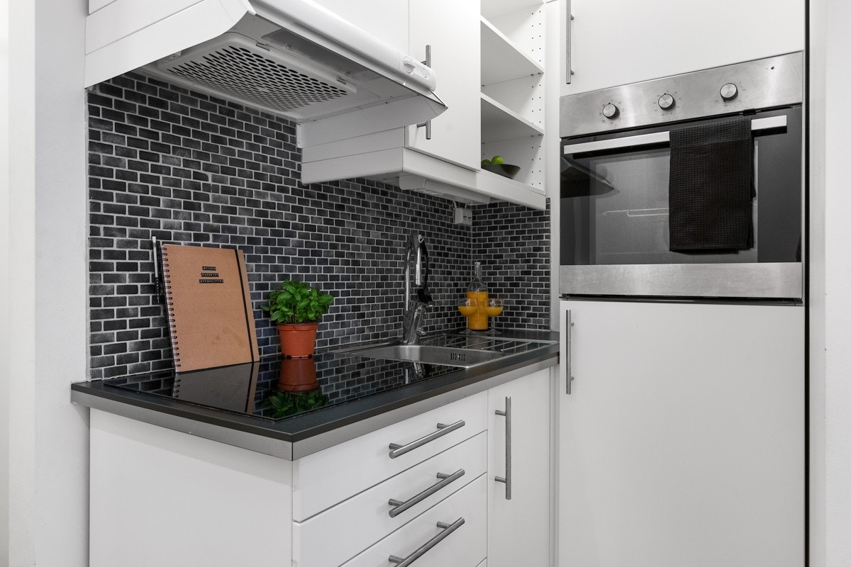 Pent kjøkken med integrert komfyr, platetopp og kjøleskap Galleribilde